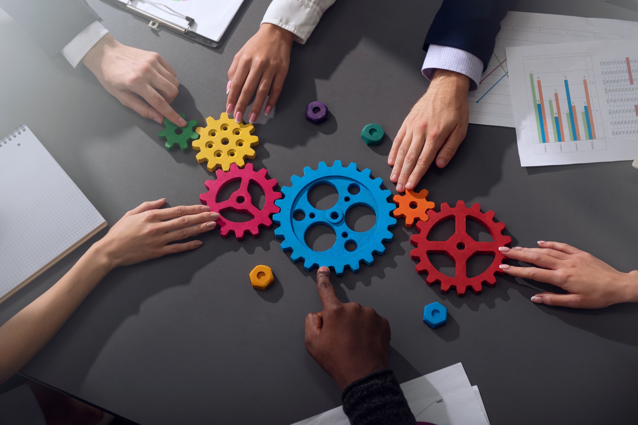 Photo of Teamwork of businesspeople work together and combine pieces of gears. Partnership and integration concept